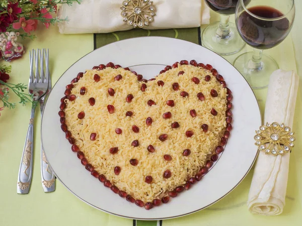 Feestelijke salade in de vorm van een hart, versierd met granaatappelpitten, het idee van decoratie voor Valentijnsdag, Horizontale oriëntatie, Close-up — Stockfoto