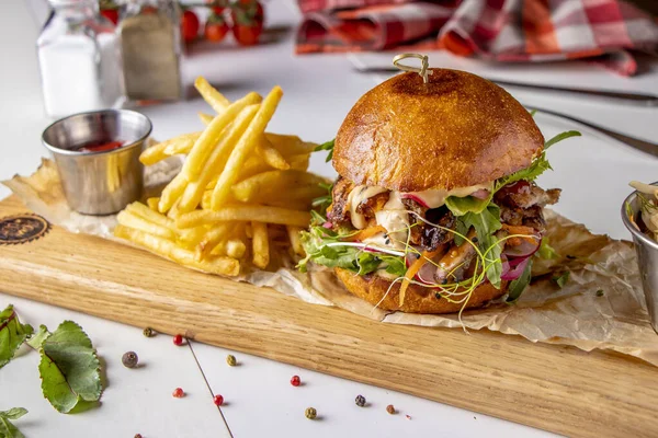 Vegetarian fresh burger with mushrooms and vegetables, served with french fries on a wooden board, healthy fast food, Closeup