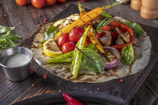Hiasan sayuran dan jamur yang dipanggang pada papan kayu, makanan vegetarian, hidangan restoran, orientasi horisontal — Stok Foto