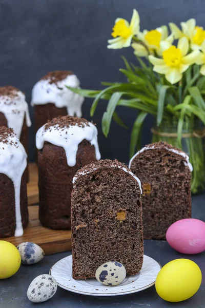 Still life with cut chocolate Easter cake and multi-colored Easter eggs on a dark background, Vertical orientation — Stock Photo, Image