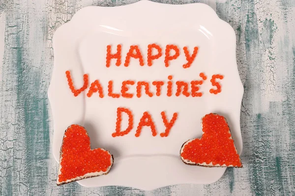 L'iscrizione Buon San Valentino dal caviale rosso su un piatto bianco con tartine — Foto Stock
