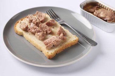 Healthy food, Sandwich with cod liver on a gray plate on a white background
