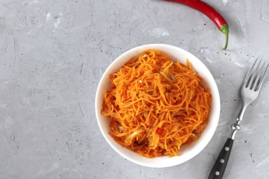 Gri arka planda beyaz bir kasede Kore havucu, yakın plan, Üst Manzara