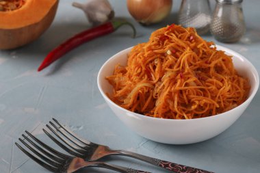 Açık mavi arka planda beyaz bir kasede Kore kabağı, yakın plan.