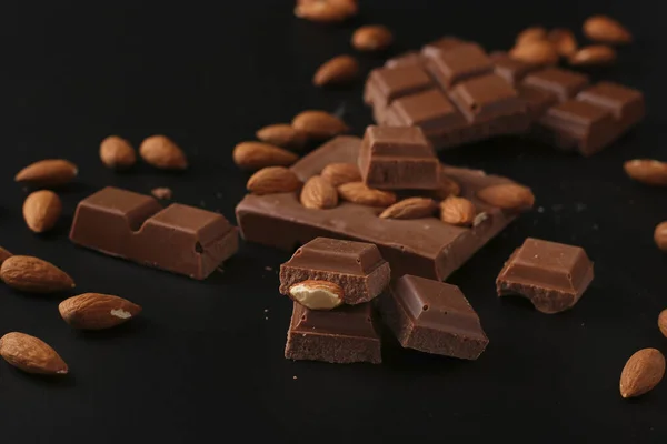 Ciocolată cu migdale și scorțișoară pe un fundal întunecat — Fotografie, imagine de stoc
