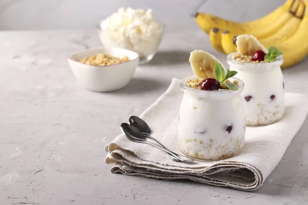 格拉诺拉甜甜蜜蜜 带有浆果 奶酪和天然酸奶 是一种美味而健康的早餐 位于灰色背景的玻璃瓶中 复制空间 — 图库照片