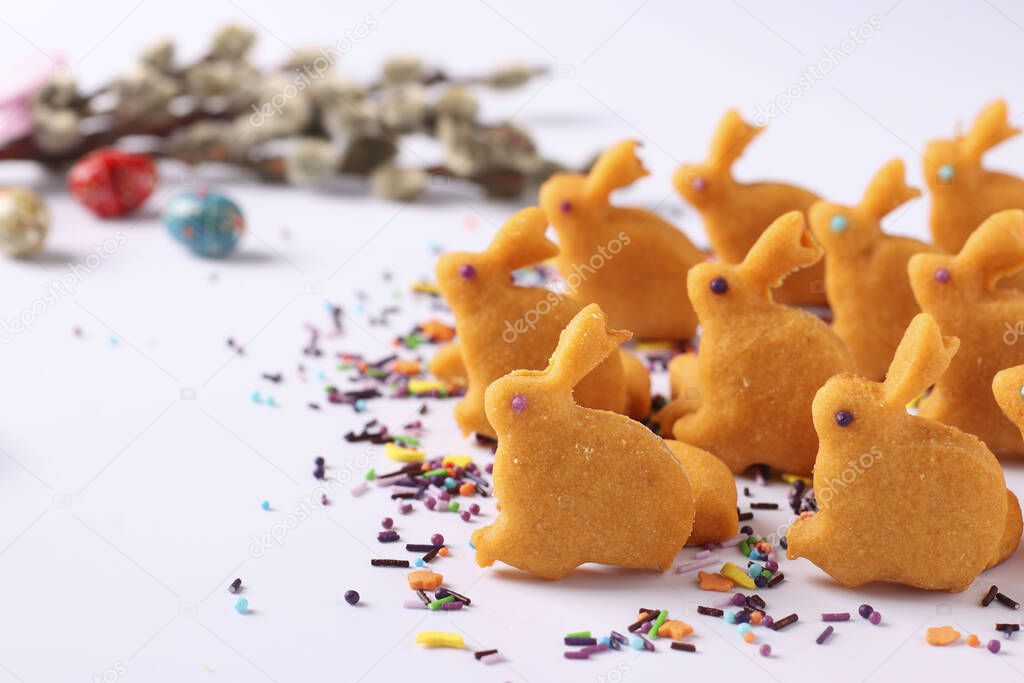 Easter gingerbread in the form of cute rabbits on sticks located on a white background, top view, the concept of the spring church holiday, Horizontal format