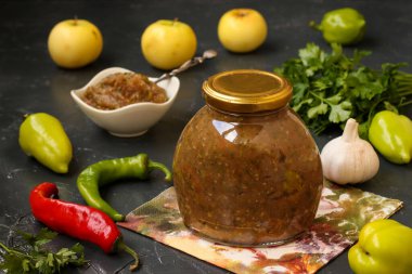 Acı biber, sarımsak, elma, maydanoz ve dereotlu ev yapımı sos, koyu arkaplanda, yatay formatta..
