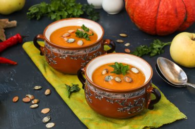 Koyu arkaplanda ev yapımı balkabağı kremalı çorba, yatay format, yakın plan.