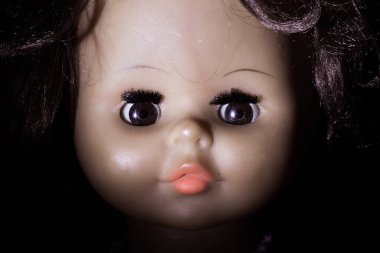 Esmer arka planda eski oyuncak bebek