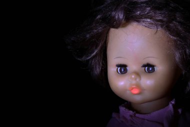 Esmer arka planda eski oyuncak bebek