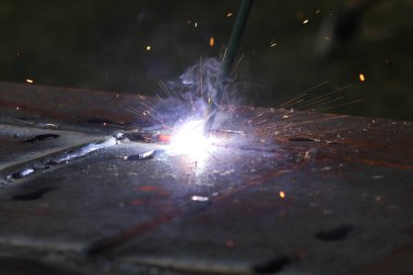 İşçi fabrikada çelik kaynıyor.