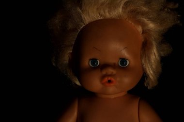 Esmer arka planda eski oyuncak bebek