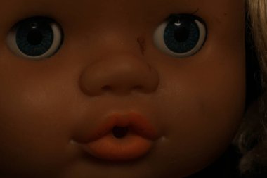 Esmer arka planda eski oyuncak bebek