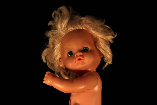 Old doll on dark background