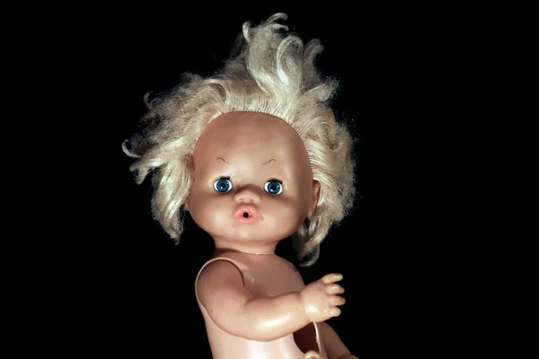 Old doll on dark background