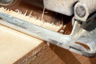 Marangoz bahçede ahşap kalaslarla çalışıyor. 