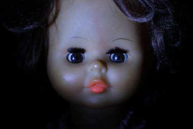 Esmer arka planda eski oyuncak bebek