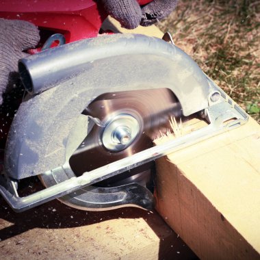 carpenter working with wooden planks in the garden  clipart