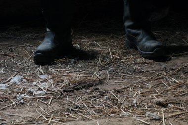 Siyah deri çizmeli adam ahırda.