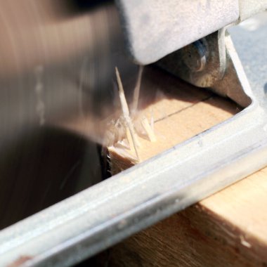 Marangoz bahçede ahşap kalaslarla çalışıyor. 