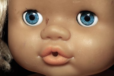 Esmer arka planda eski oyuncak bebek