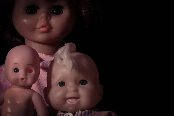 Old dolls on dark background