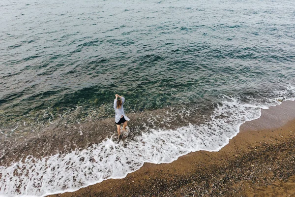Deniz kıyısında yürüyen güzel bir kadının hava manzarası. — Stok fotoğraf