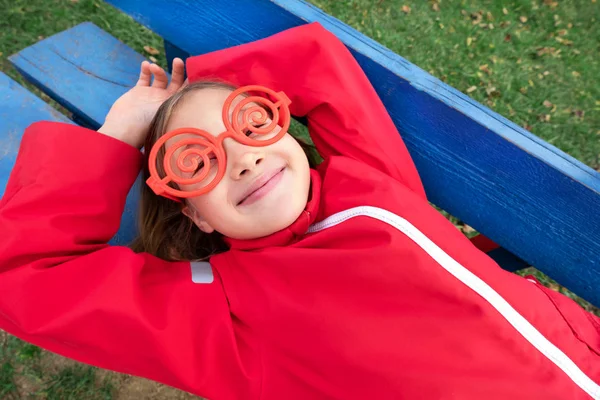 Lány napszemüveggel és piros dzsekivel — Stock Fotó