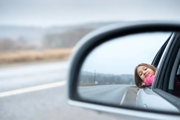 Молодая девушка ездить на машине и смотреть в открытое окно — стоковое фото