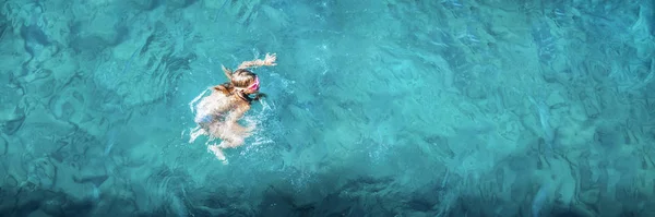 Młoda dziewczyna w strojach kąpielowych leżąca w błękitnej wodzie, widok z lotu ptaka — Zdjęcie stockowe