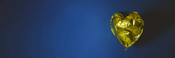 Воздушный шар в форме золотого сердца — стоковое фото