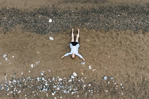 坐在海滩上的年轻女子的空中照片 — 图库照片