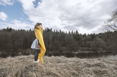 Tıbbi koruyucu maskeli üzgün bir genç kız.