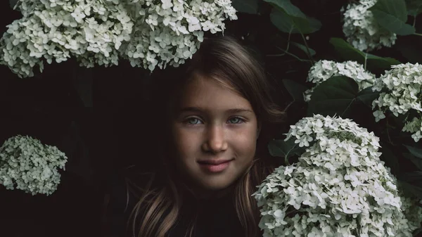 Menina bonito cheirando lilás — Fotografia de Stock