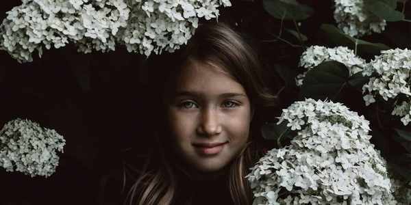 Menina bonito cheirando lilás — Fotografia de Stock