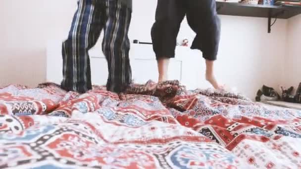 Zwei glückliche Kinder springen aufs Bett — Stockvideo