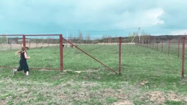 Çayırda buzağıyla oynayan bir kız