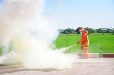 Nasıl bir yangın söndürücü kullanılacağını gösteren itfaiyeci