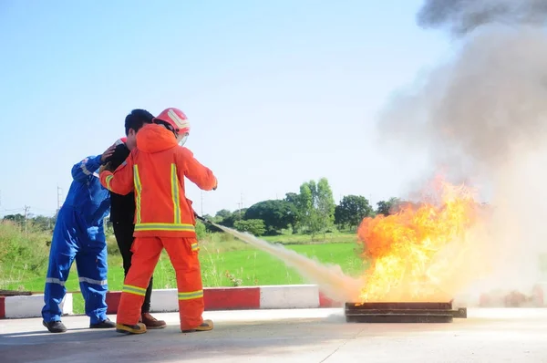 Instructor training how to use a fire extinguisher Stock Photo