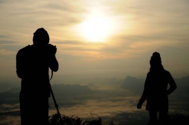 Bir fotoğrafçı çekimi kız gündoğumu sırasında silüeti