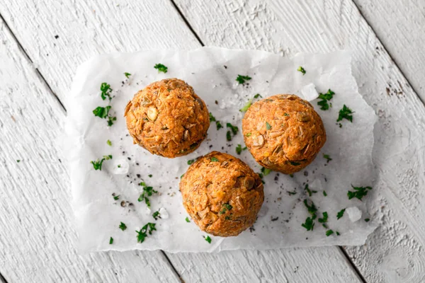 Vegan Lentil Meatballs on Baking Paper on White Wooden Surface