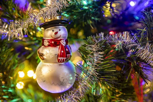 ของเล่นสโนว์แมนที่แขวนอยู่บนต้นคริสต์มาสที่ตกแต่ง สโนว์แมนและบอลคริสต์มาส . — ภาพถ่ายสต็อก