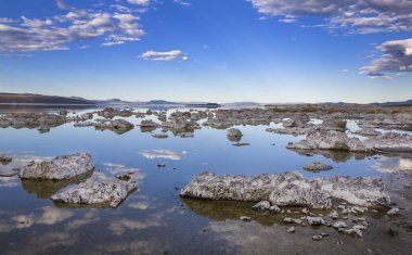 Yaz boyunca Mono Gölü 'nde doğu gölleri, yansımalı sakin sular, gökyüzünde bulutlar, suda kayalar, Kaliforniya, ABD