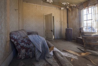 Hayalet şehir Bodie 'nin eski bir evinin oturma odası, Kaliforniya' da eski bir servet avcısı kasabası, odada kanepe ve fırın, ABD