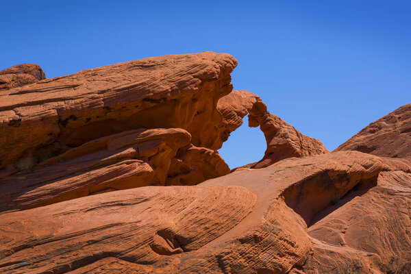 Red rock formation named Arch Rock in the Valley of Fire, blue sky, USA