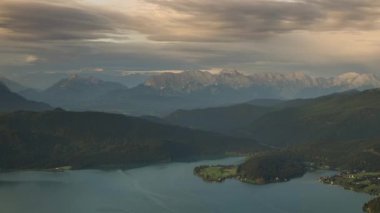 Walchensee Gölü 'nün gün batımında zaman kaybı, Wetterstein Dağı' nın arka planında güneş ışığı, hareket eden bulutlar ve güneş ışınları, Bavyera