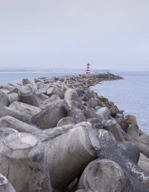 Portekiz, Peniche Limanı 'ndaki kırmızı ve beyaz fenerde köstebek ve dalga kırıcı.