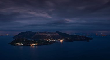 Volkan adası Vulcano 'nun panorama manzarası, gece boyunca gökyüzünde dramatik bulutlar, Sicilya İtalya