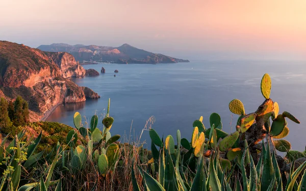 Günbatımında Volkan Adası 'na bakan Lipari adası kaktüsüyle kıyı şeridi, kayalıklar ve okyanus, Sicilya İtalya